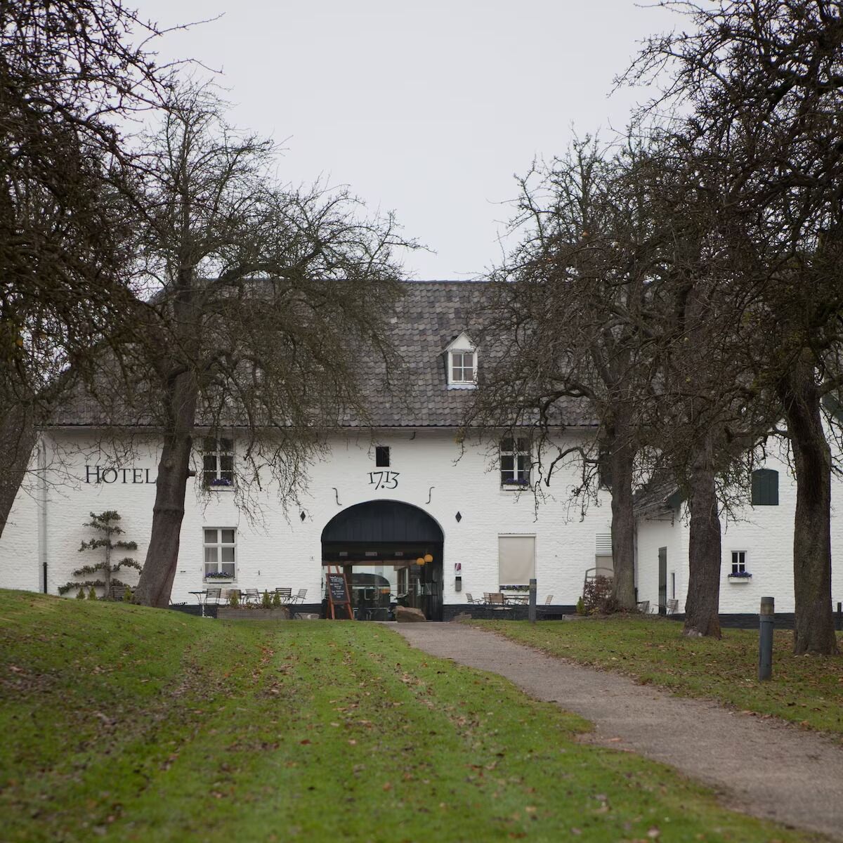 A white building with a sign reading "HOTEL" and the number "17.5" above the entrance.