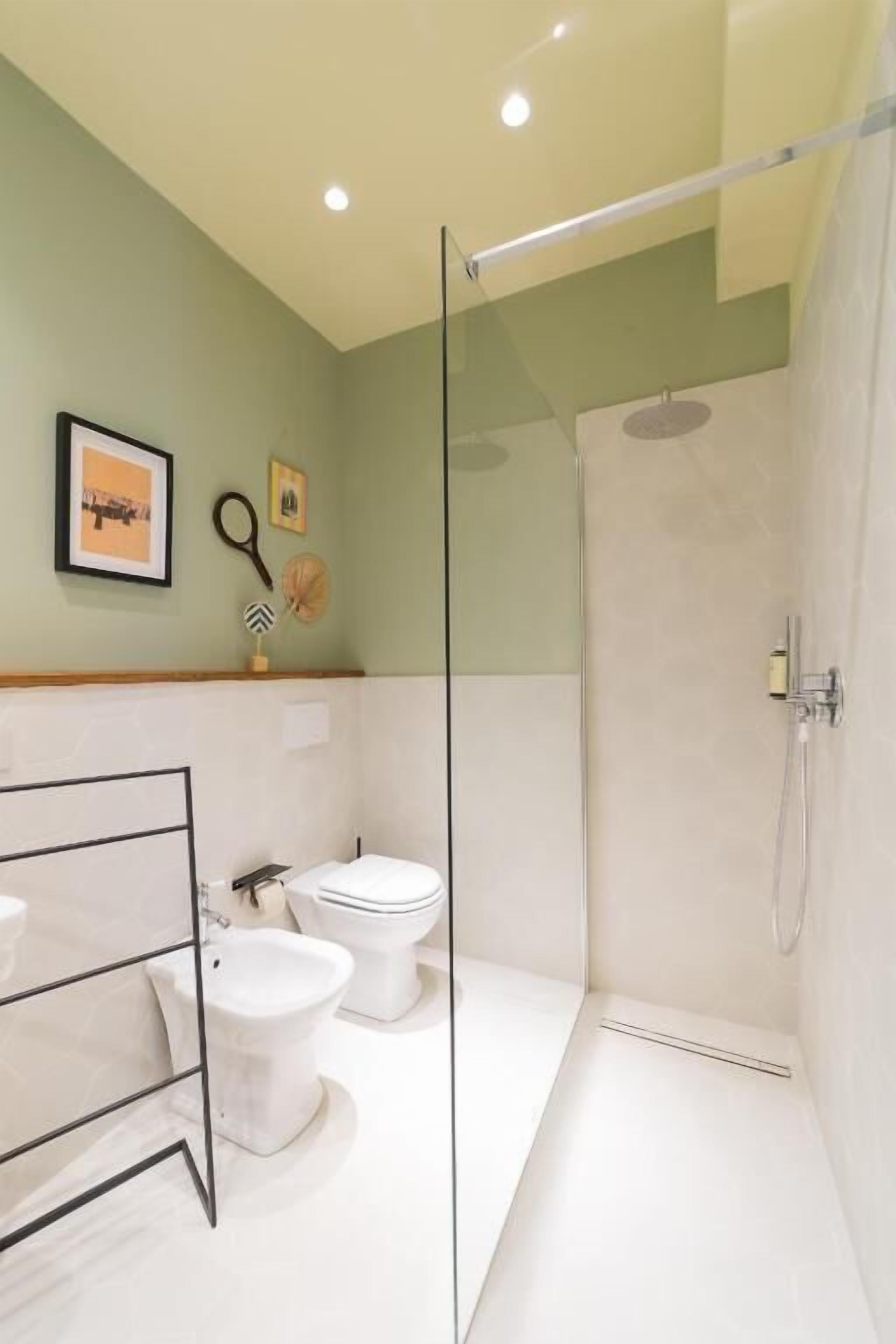 Une salle de bain moderne avec une douche à parois de verre, des toilettes blanches et un bidet.