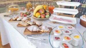 Un ricco buffet per la colazione con dolci, frutta e bevande.