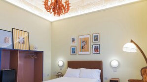 Una camera da letto con soffitto a motivi in mattoni, un letto, un armadio, una scrivania e una sedia.