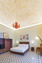 Una camera da letto con soffitto a motivi in mattoni, un letto, un armadio, una scrivania e una sedia.
