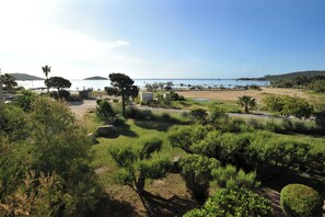 A coastal area with a parking lot, greenery, and a view of the sea. - Cala di Sole (Lecci)