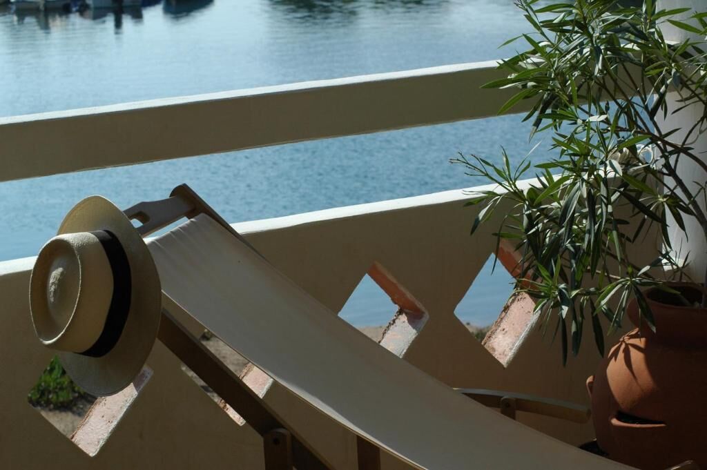 A balcony with a chair and a potted plant.