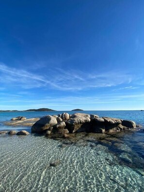 A clear view of a rocky shoreline with calm water and a clear sky. - Cala di Sole (Lecci)