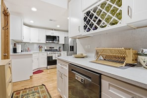 A modern kitchen with white cabinets, stainless steel appliances, and a wine rack. - NEW! Fully Updated Jr. 1 Bed, Steps from Lincoln Park by AllSet Turnover (Chicago)