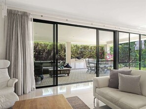 A modern living room with a sofa, a coffee table, and a dining area with a table and chairs. - Ile-de-Re: Generous Garden Home by the Beach (Dunsborough)