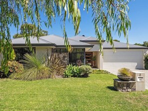 A modern house with a well-maintained lawn, a stone pathway, and a variety of plants. - Ile-de-Re: Generous Garden Home by the Beach (Dunsborough)