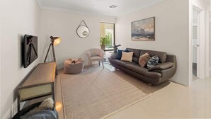 Ein modernes Wohnzimmer mit einer Couch, einem Sessel und einer Lampe.