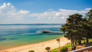 A beach with a pier and a boat docked at the end. - Cowes Beachfront Penthouse (Cowes)