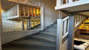 Eine Treppe mit weißer Geländer und einer verzierten Decke.