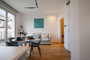 Un espace de vie moderne comprenant un coin repas, un canapé et une vue sur l’extérieur.