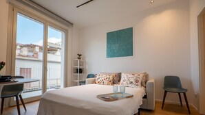 A bedroom with a bed, a desk, a chair, and a balcony view. - Holiday Home 'Terrazza Marconi' with Sea View, Wi-Fi and Air Conditioning (Castellammare del Golfo)