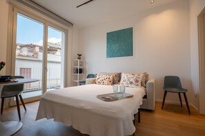 Une chambre avec un lit, un bureau, une chaise et une vue sur le balcon.