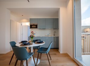 Eine moderne Küche mit grauen Schränken, einer weißen Arbeitsplatte und einem eingebauten Backofen.