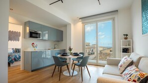 A modern apartment with a kitchen, dining area, and balcony. - Holiday Home 'Terrazza Marconi' with Sea View, Wi-Fi and Air Conditioning (Castellammare del Golfo)