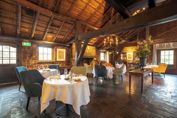 Savor candlelit dining beneath rustic beams and cozy textures.