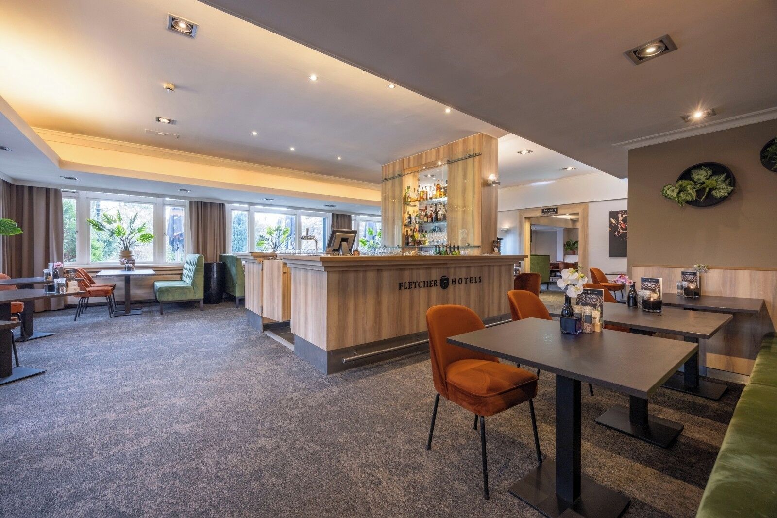 Un vestíbulo de hotel con mostrador de recepción, zona de estar y un bar.