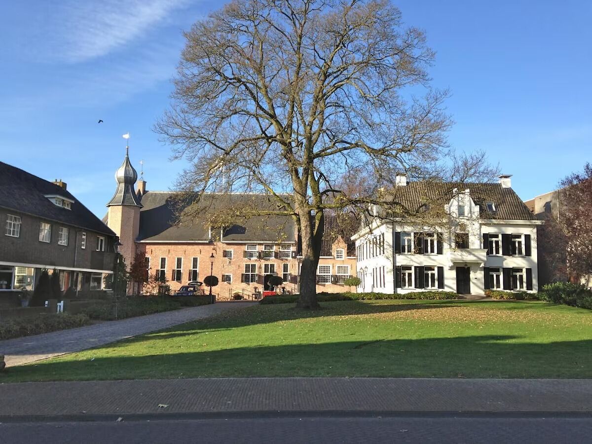 A large building with a prominent tower, surrounded by a well-maintained lawn and a pathway.