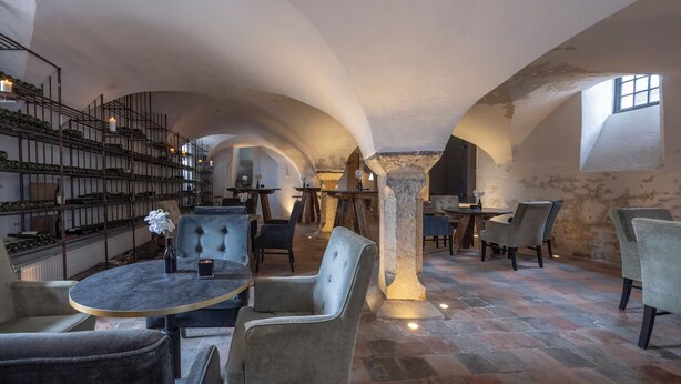 Un intérieur spacieux avec des plafonds en voûte, une cave à vin et des coins salon confortables.