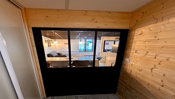 A wooden-paneled room with a view into a dining area. - Family Apartment in La Bourboule (La Bourboule)