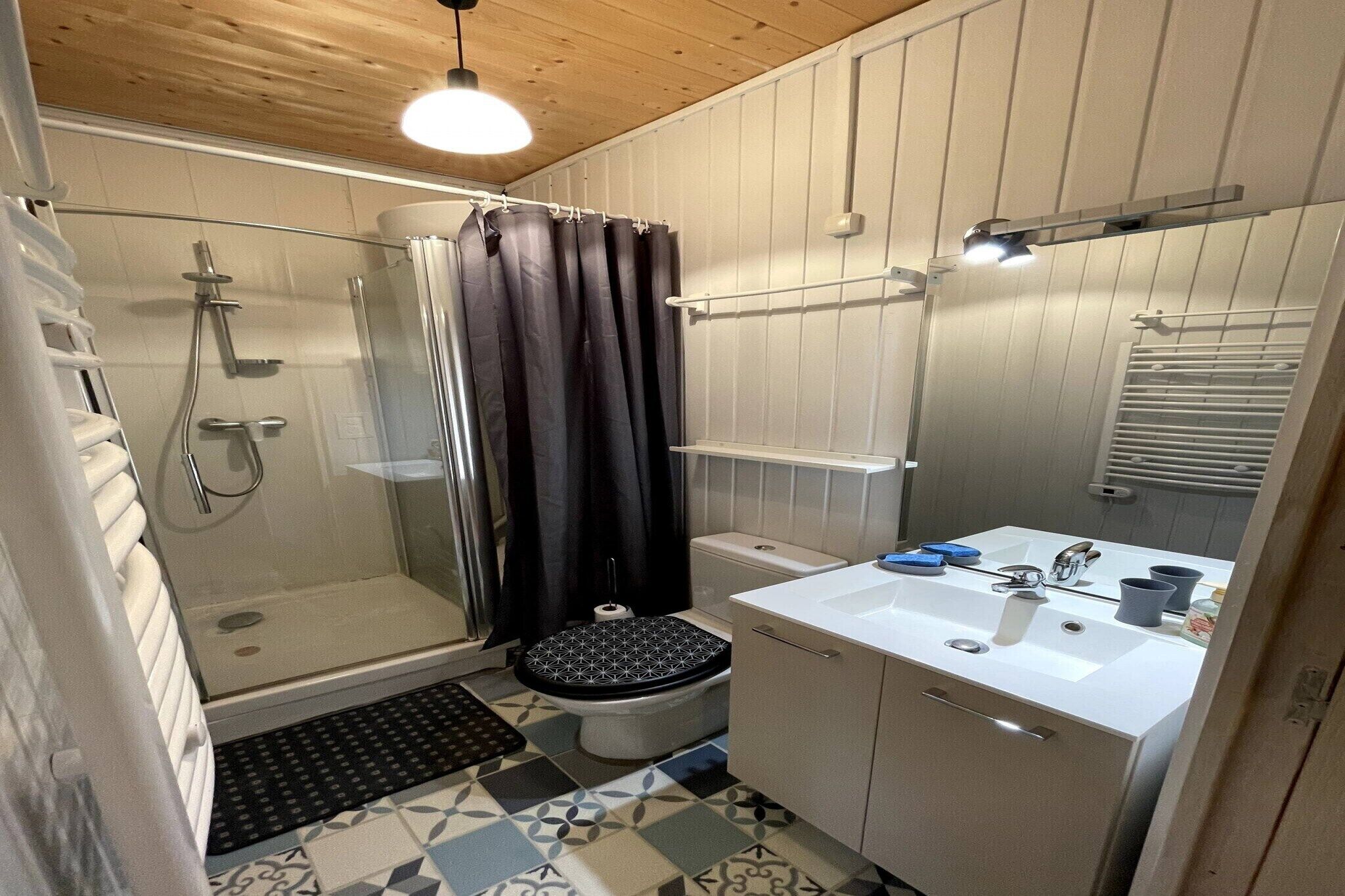 A compact bathroom with a shower, toilet, and sink.
