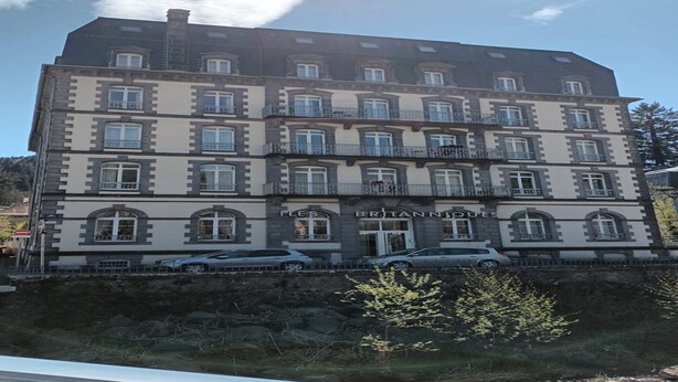 Un immeuble à plusieurs étages, sur lequel on peut lire l’inscription « LES BRITANNIQUES », ce qui indique qu’il s’agit d’un hôtel. On y voit plusieurs fenêtres, des balcons et une entrée bien visible.