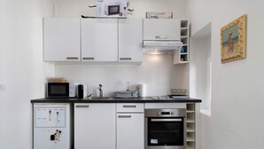 A compact kitchen with white cabinets, a microwave, a dishwasher, and a small refrigerator. - Studio Apartment 'Vintage' with Wi-Fi and Air Conditioning (Nice)