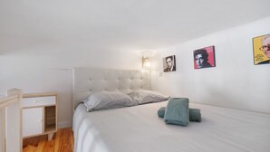 A bedroom with a bed, a bedside table, a lamp, and wall art. - Studio Apartment 'Vintage' with Wi-Fi and Air Conditioning (Nice)