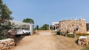 A dirt road leading to a stone building with a white car parked nearby. - Apartment 'Tenuta Degli Asinelli - Casale' with Sea View, Wi-Fi and Air Conditioning (Alliste)