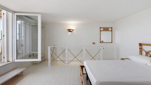 A minimalist bedroom with a bed, a bench, a wardrobe, and a mirror. - Apartment 'Tenuta Degli Asinelli - Casale' with Sea View, Wi-Fi and Air Conditioning (Alliste)