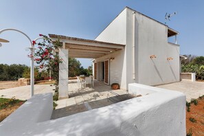A modern house with a covered patio, a dining area, and a garden. - Apartment 'Tenuta Degli Asinelli - Casale' with Sea View, Wi-Fi and Air Conditioning (Alliste)
