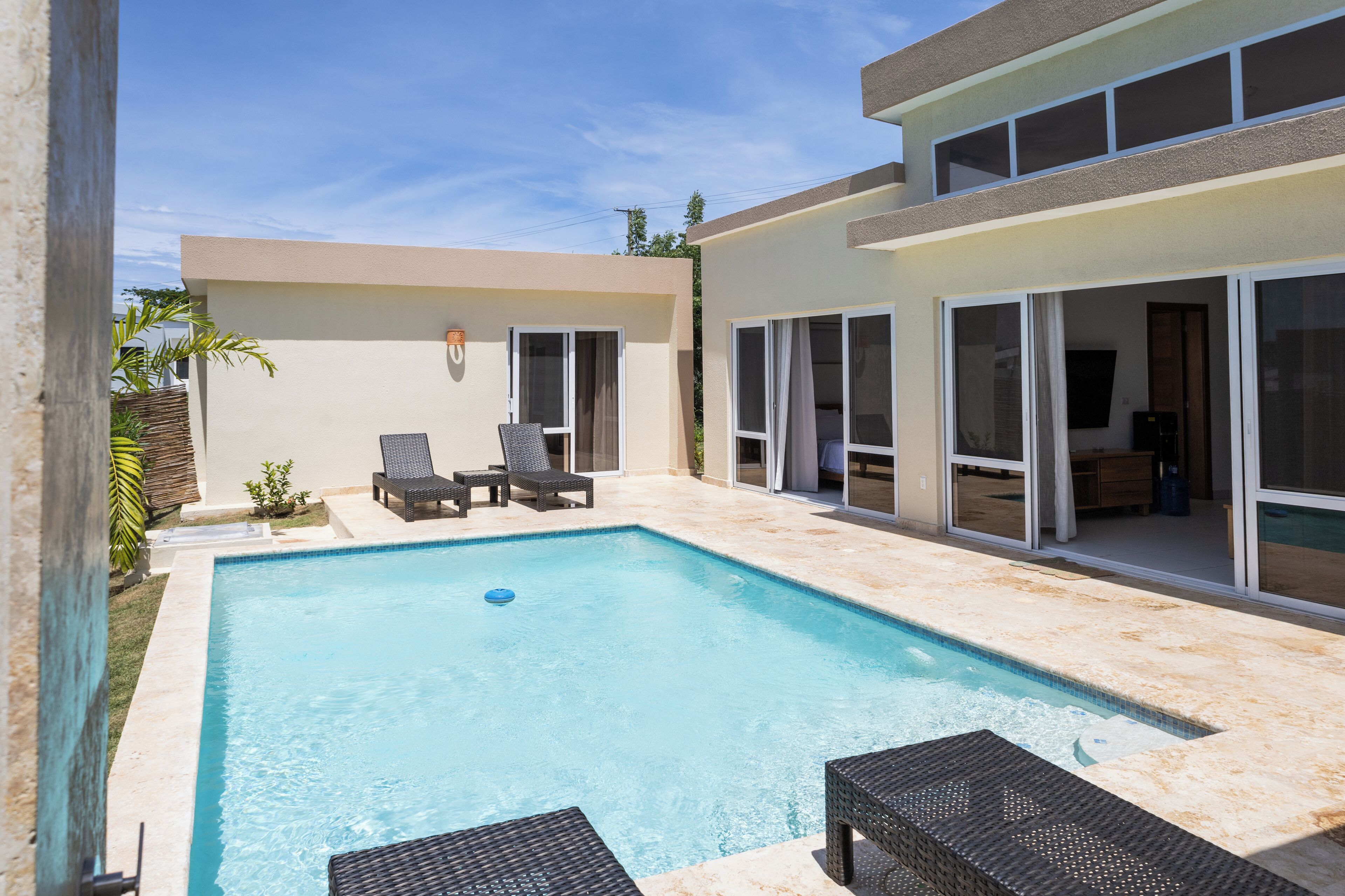 Ein Schwimmbecken mit Liegestühlen und einer Terrassenfläche.