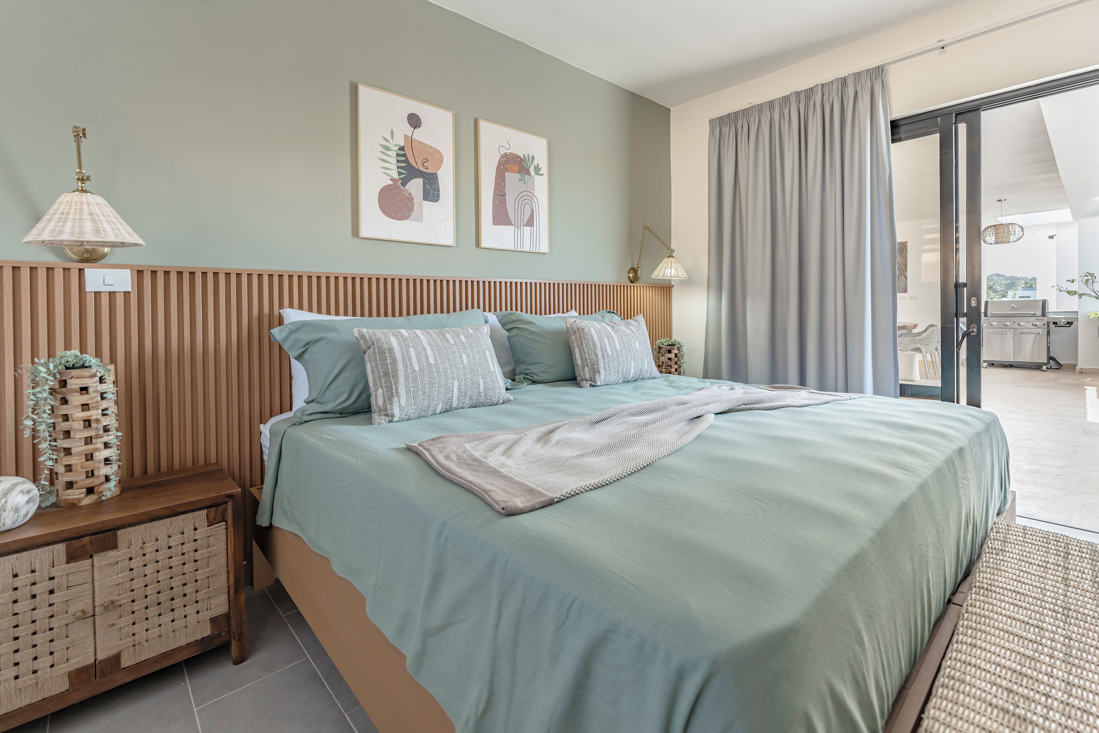 A bedroom with a bed, bedside tables, a lamp, and artwork on the wall.