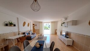 A modern kitchen with a dining area, a sofa, and a TV. - Villa Mariamar with Private Pool, Wi-Fi, and Air Conditioning (Vale da Azinheira)