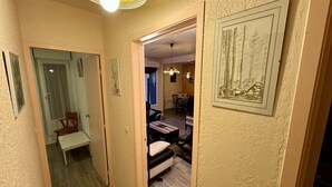 Un corridoio con una panca di legno, una porta e un quadro appeso al muro.