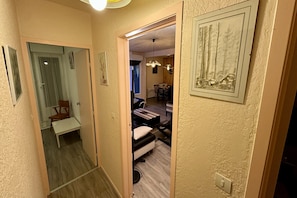 Ein Flur mit einer hölzernen Bank, einer Tür und einem gerahmten Bild an der Wand.