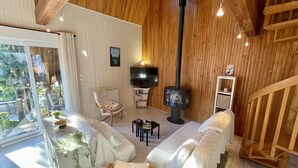 Ein gemütliches Wohnzimmer mit Kamin, bequemen Sitzgelegenheiten und einem Fernseher.