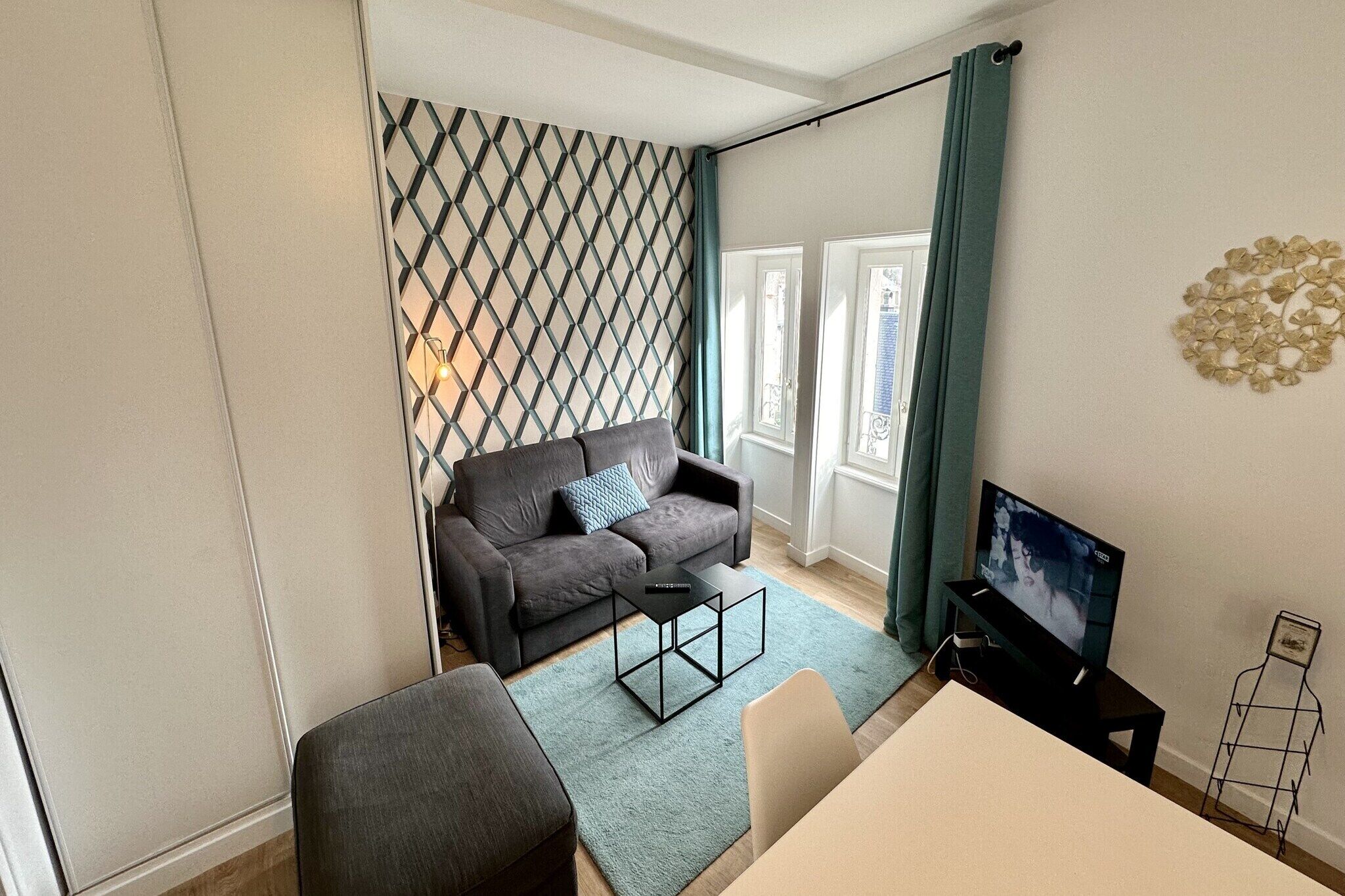 Ein modernes Wohnzimmer mit einer Couch, einem Couchtisch und einem Fernseher.