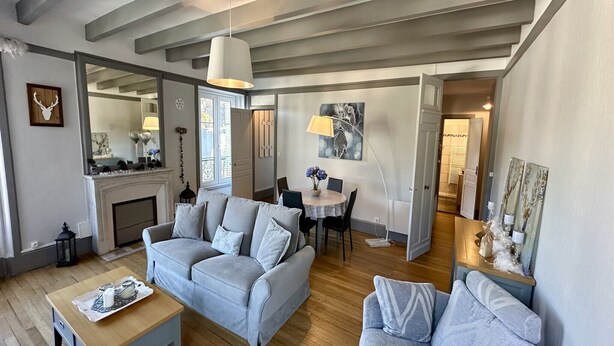 A spacious living room with a fireplace, a dining area, and a cozy seating arrangement. - Quiet corner near the mountain road (Mont-Dore)