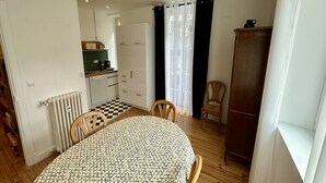 Ein kompakter Wohnbereich mit Essplatz, Küchenzeile und großem Kleiderschrank.