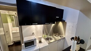 Une cuisine moderne équipée d’appareils électroménagers en acier inoxydable, d’un four à micro-ondes et d’un évier.