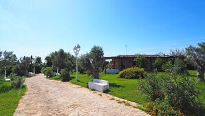 A stone pathway leading to a building with a stone facade, surrounded by greenery and a clear blue sky. - Room 'Villa Sterlizia - Lantana' with Shared Pool, Wi-Fi and Air Conditioning (Alliste)