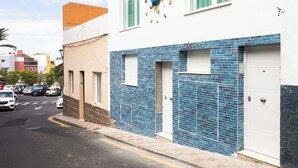 Ein Gebäude mit weißer Fassade, einem unteren Abschnitt aus blauen Fliesen und dekorativen Pfauenfiguren.