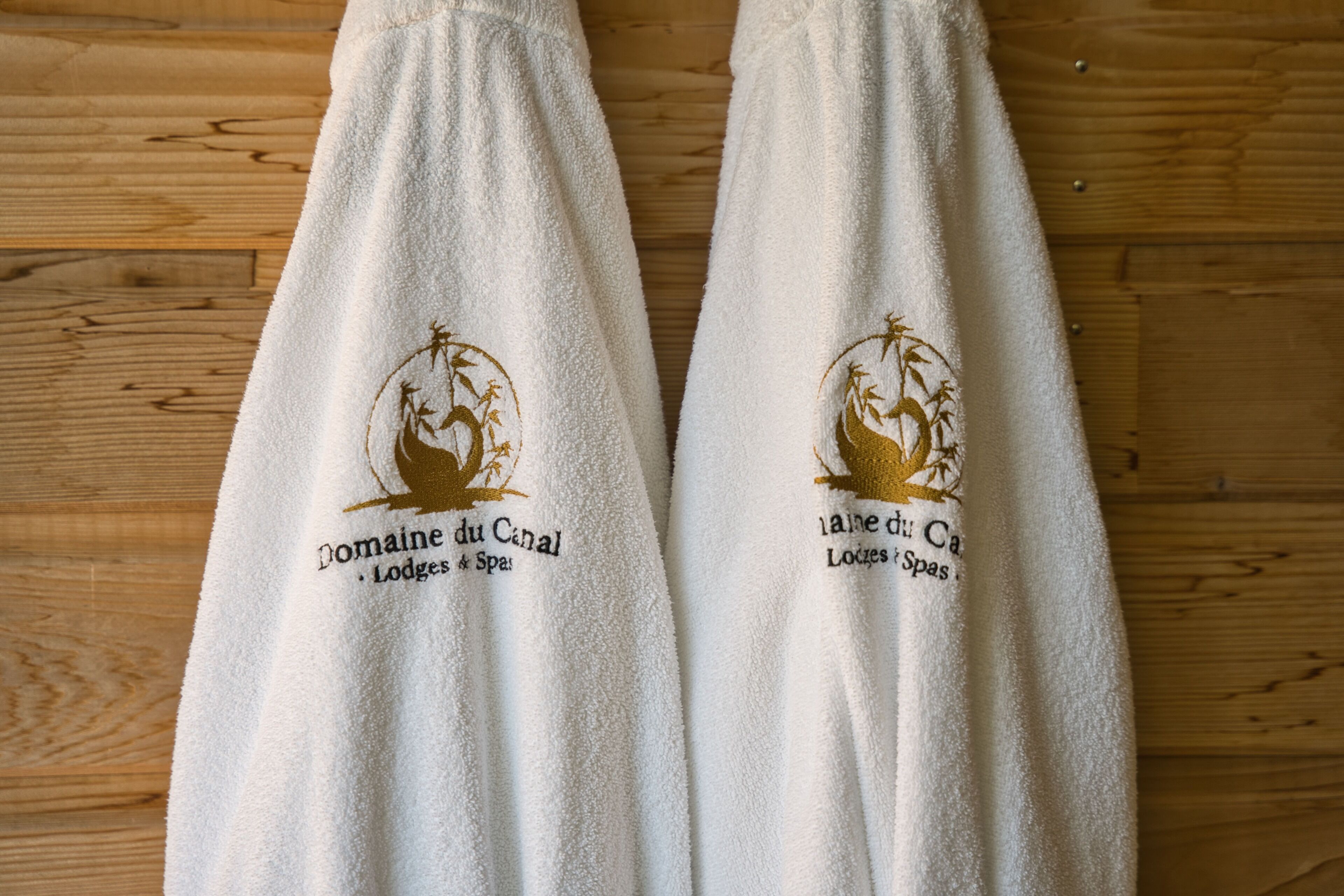 Dos toallas blancas con un logo y texto.