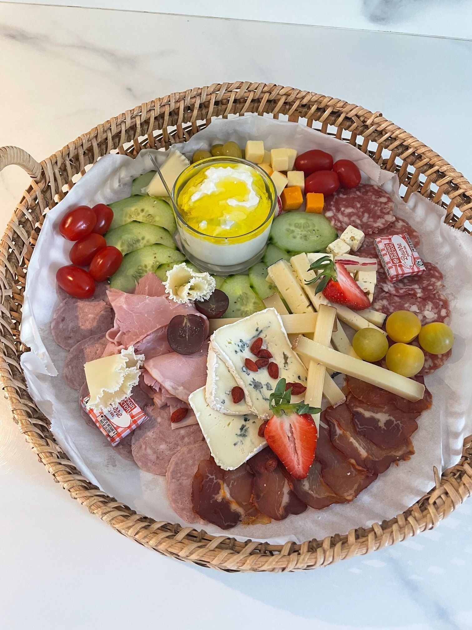 A charcuterie board with various cheeses, meats, and fruits.