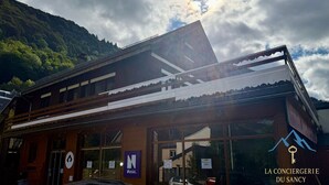 Een hotel met een traditionele houten gevel, een grote glazen ingang en een bord met 'Netski'.