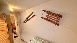 Ein Zimmer mit einem Etagenbett, einer Holzleiter und einem an der Wand befestigten Ablage.