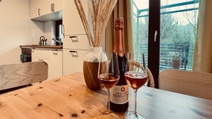 A wooden table with a bottle of Duchess & Fragolin wine, two glasses, and a vase with dried plants. - Holiday home, sea, jacuzzi, for 3 people (Rozewie)