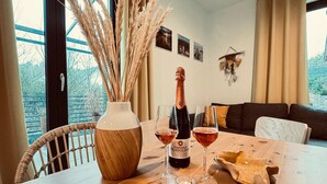 Ein Holztisch mit einer Flasche Duchessina Fragolino Wein, zwei Gläsern, einer Vase mit getrockneten Pflanzen und einem rustikalen Brotkorb.