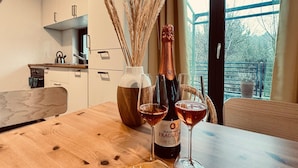 A wooden table with a bottle of Duchess & Fragolin wine, two glasses, and a vase with dried plants. - Holiday home, sea, jacuzzi, for 6 people (Rozewie)
